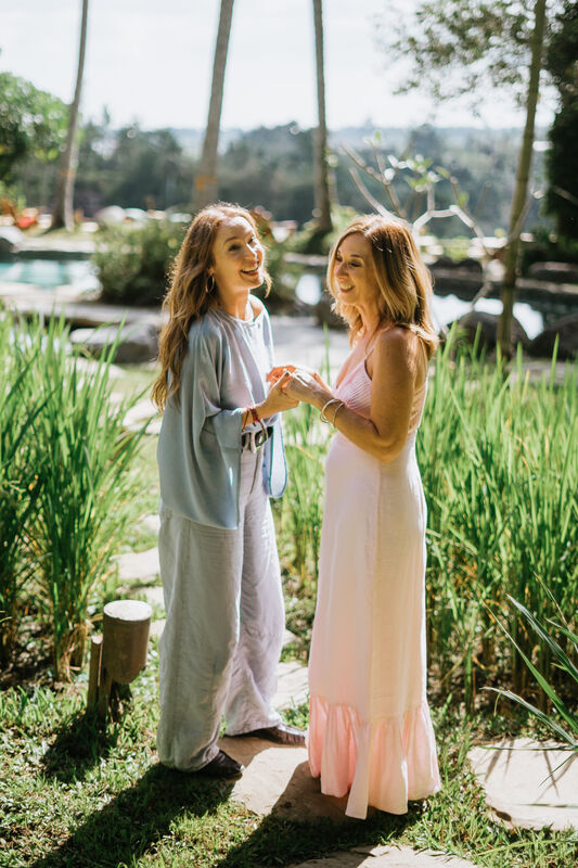 Julie Wright Halbert holding both hands of another woman, mid-conversation