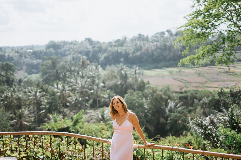 Julie Wright Halbert at a bamboo rail above a Balinese valley, looking out
