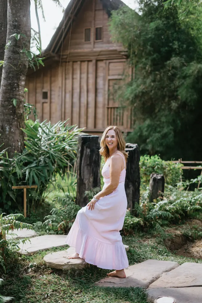 Julie Wright Halbert seated on a stone path in a garden